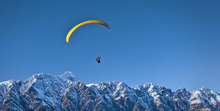Professional paragliding instructor preparing equipment in Khajjiar