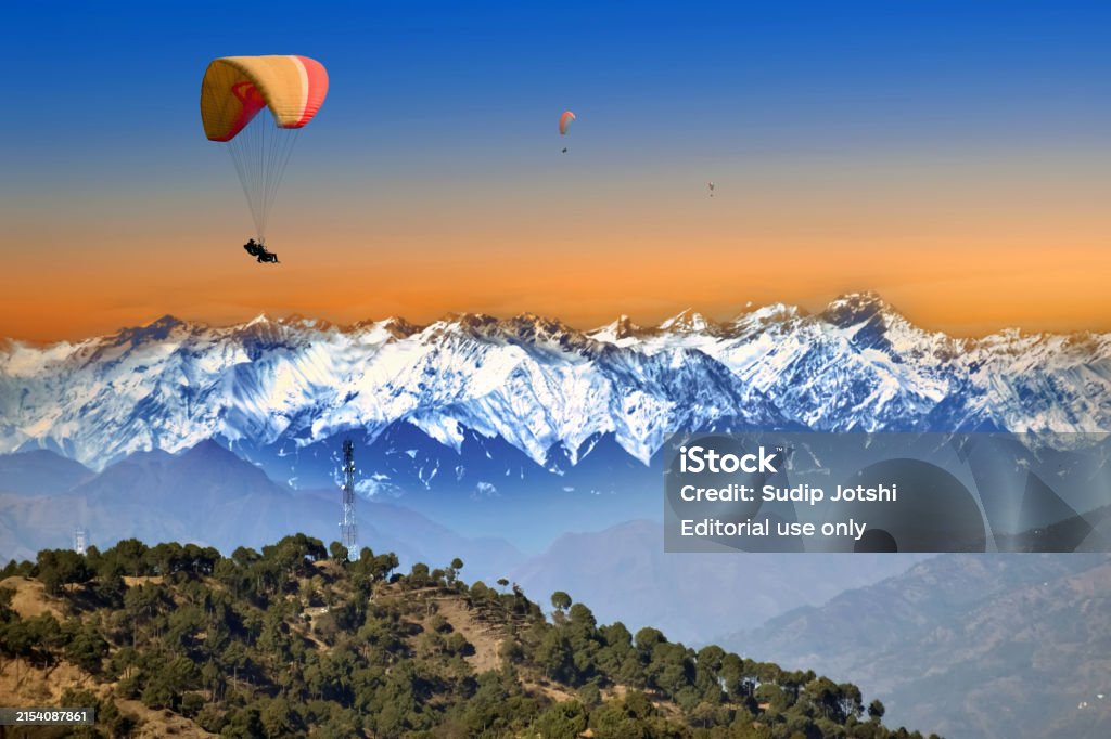Paragliding takeoff from Khajjiar plateau with forest backdrop
